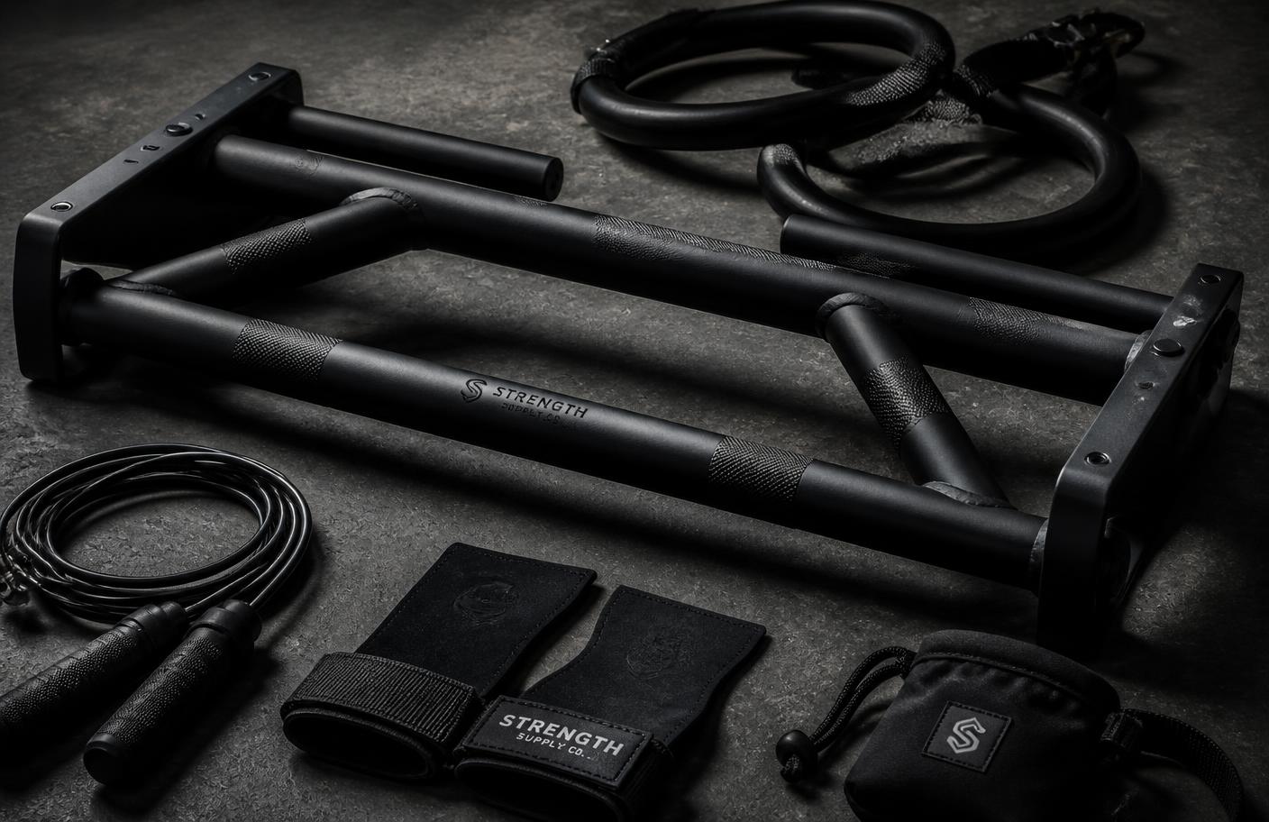 Matte black home training equipment laid out on concrete
